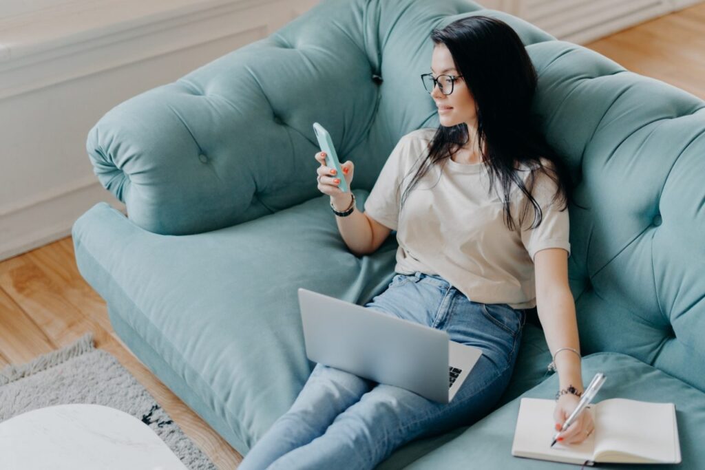 female freelancer in casual clothes focused in smartphone display checks information in internet.jpg