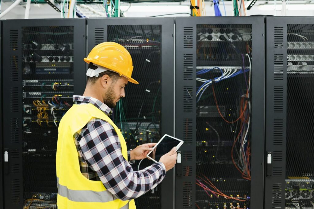 young technician man working with tablet inside big data center room.jpg